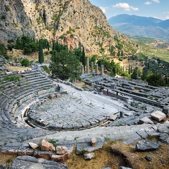 Ancient stone theater ruins at Delphi with mountainous landscape in the background