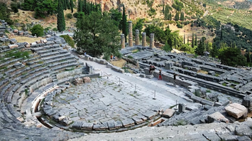 Ancient stone theater ruins at Delphi with mountainous landscape in the background