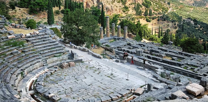 Ancient stone theater ruins at Delphi with mountainous landscape in the background