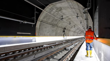 Worker inspecting tracks inside a metro tunnel