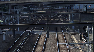 Railway tracks with overhead wires and signalling equipment at a busy junction