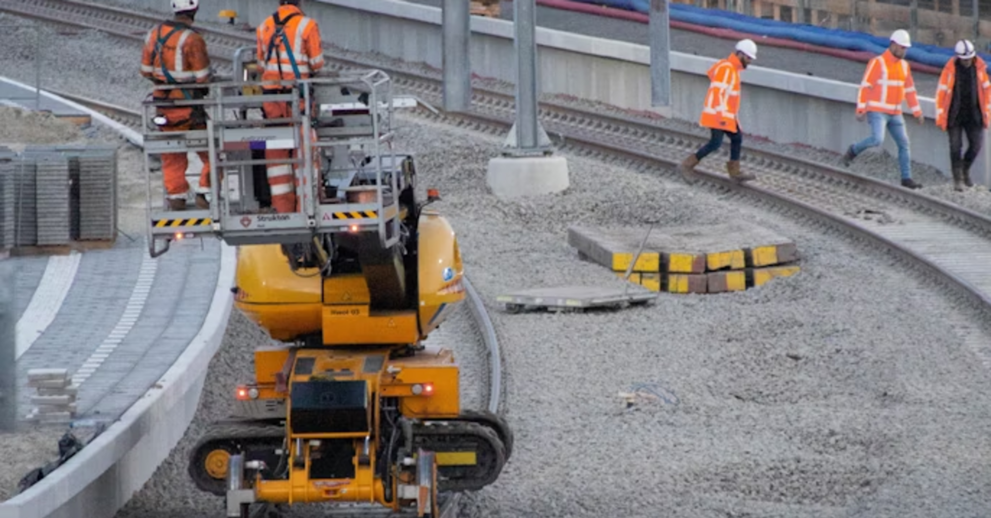 Railway workers carrying out track and infrastructure upgrades at a station construction site