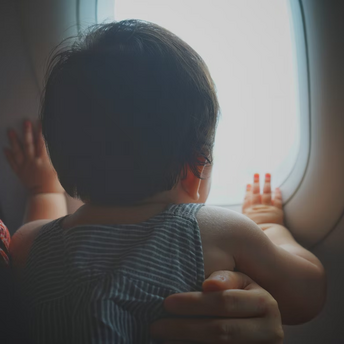 Baby looking out of an airplane window during flight