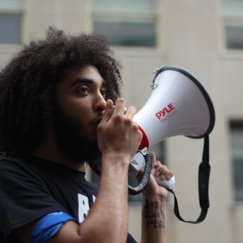 Man speaking through a megaphone outdoors