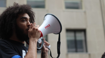 Man speaking through a megaphone outdoors