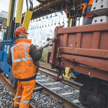 Railway worker inspecting freight carriage during track maintenance
