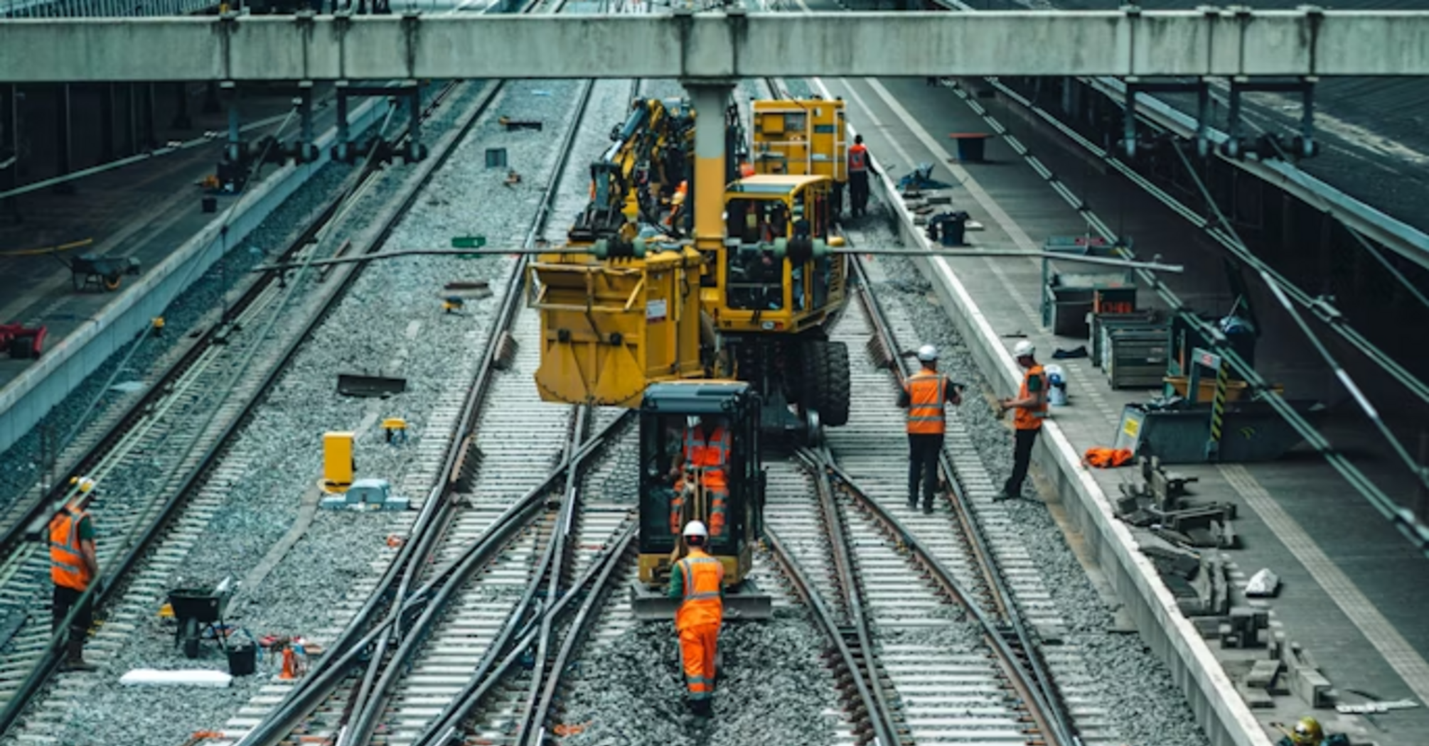 Workers carrying out railway track maintenance and upgrades at a station