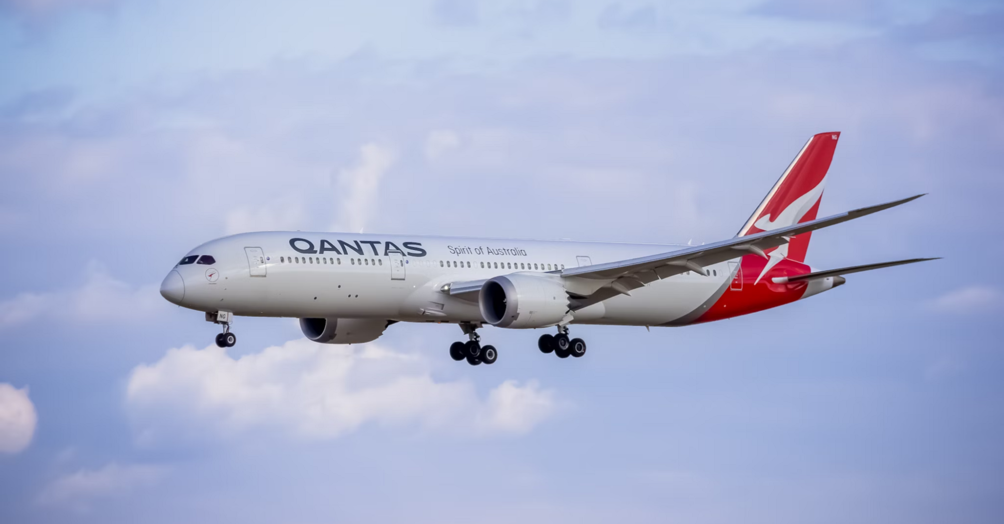 Qantas aircraft approaching for landing against blue sky