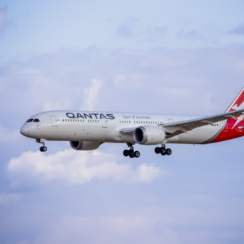 Qantas aircraft approaching for landing against blue sky