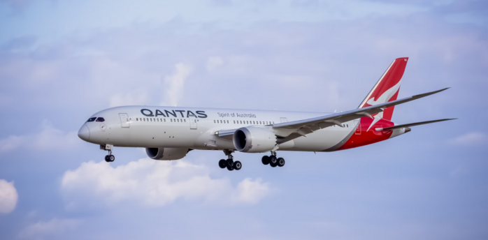 Qantas aircraft approaching for landing against blue sky