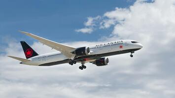 Air Canada airplane flying under cloudy sky