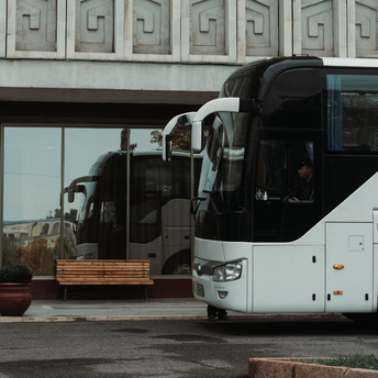 White long-distance bus parked at a station