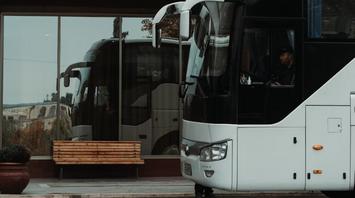 White long-distance bus parked at a station