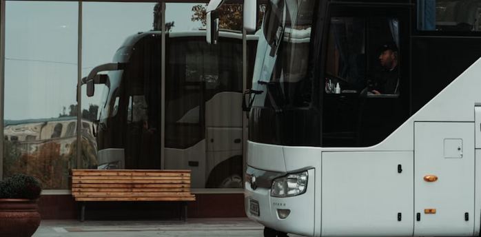 White long-distance bus parked at a station