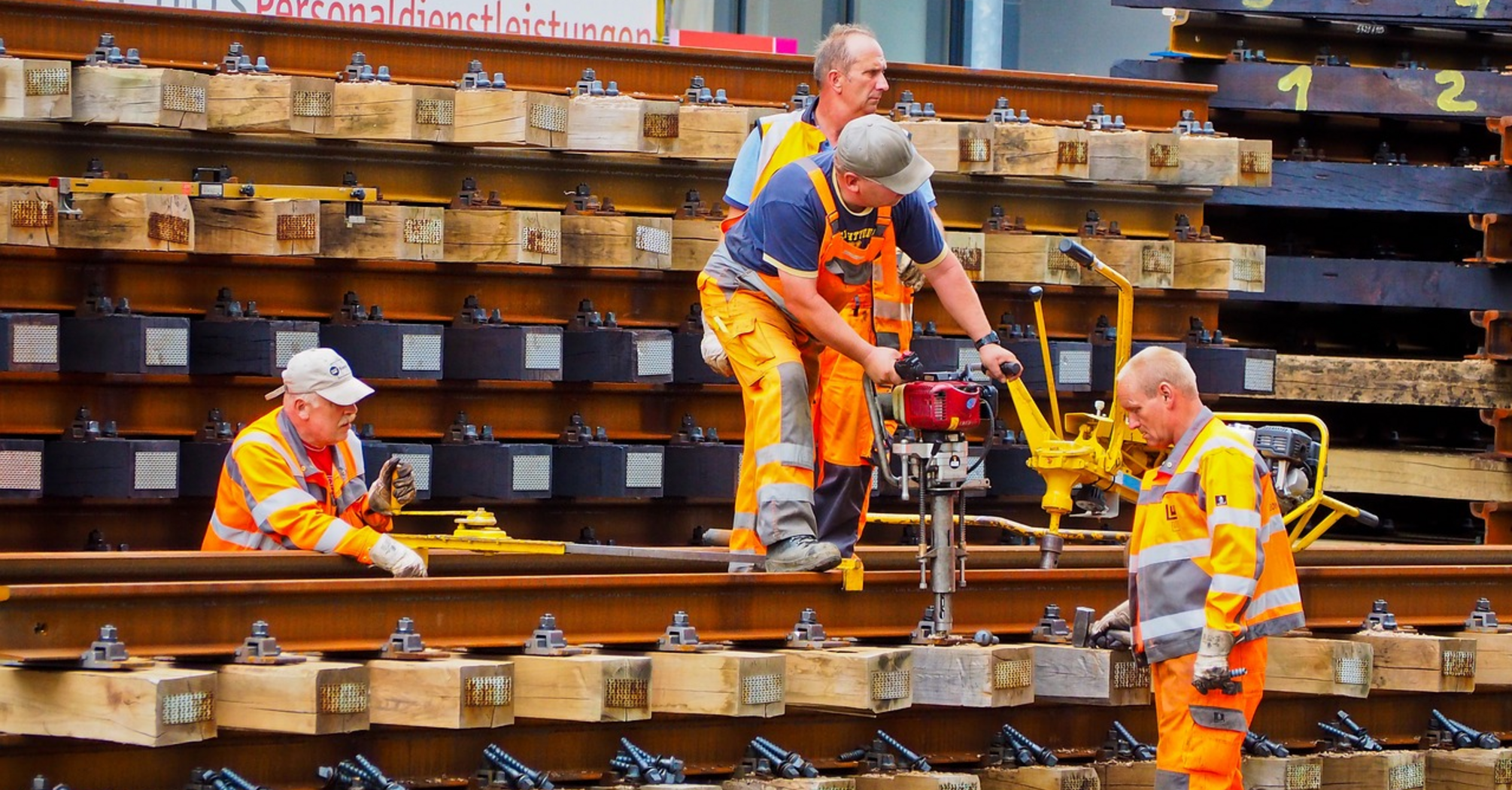 Rail maintenance workers handling track components