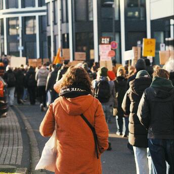 People marching in a protest with banners and signs in a city street