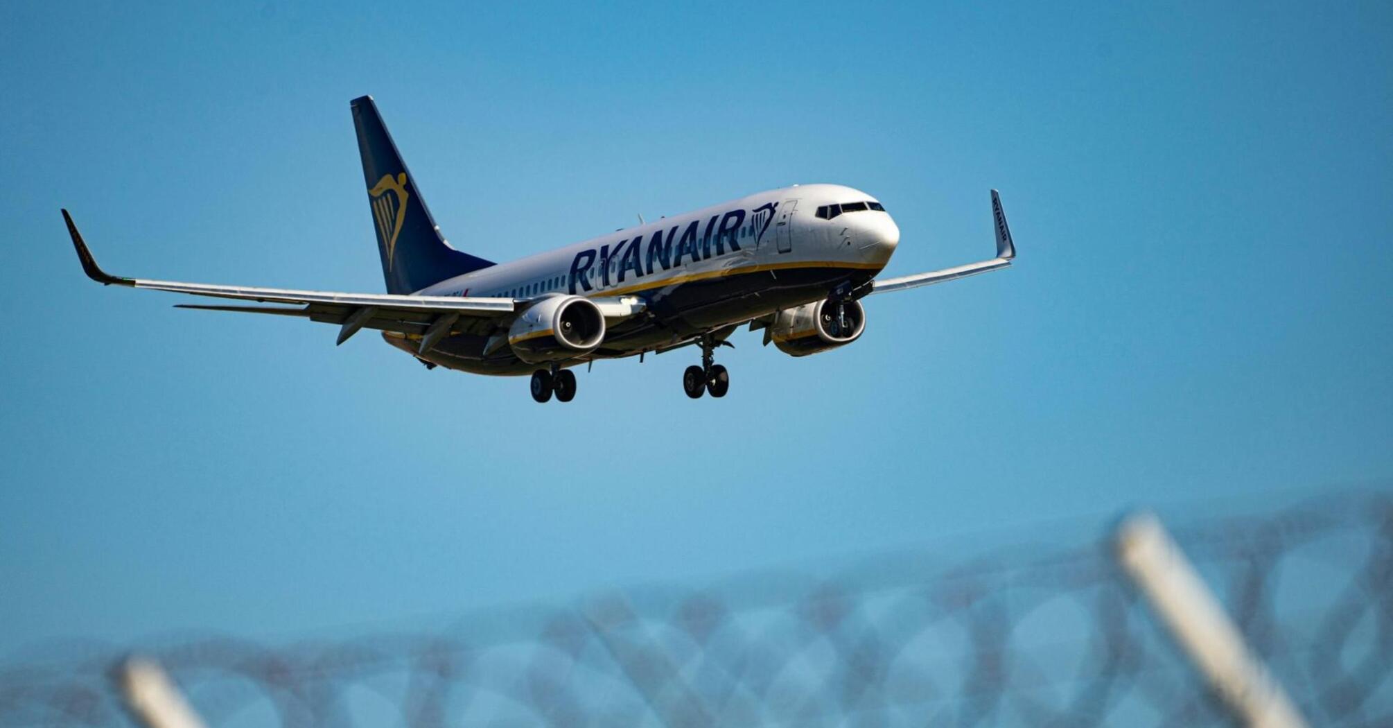 Ryanair aircraft approaching for landing against clear blue sky