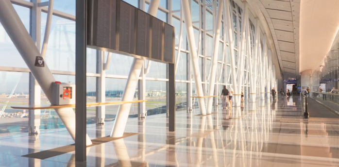Modern airport terminal corridor with passengers walking and large flight information board