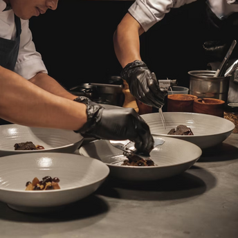 Chefs carefully plating gourmet dishes in a kitchen