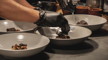 Chefs carefully plating gourmet dishes in a kitchen