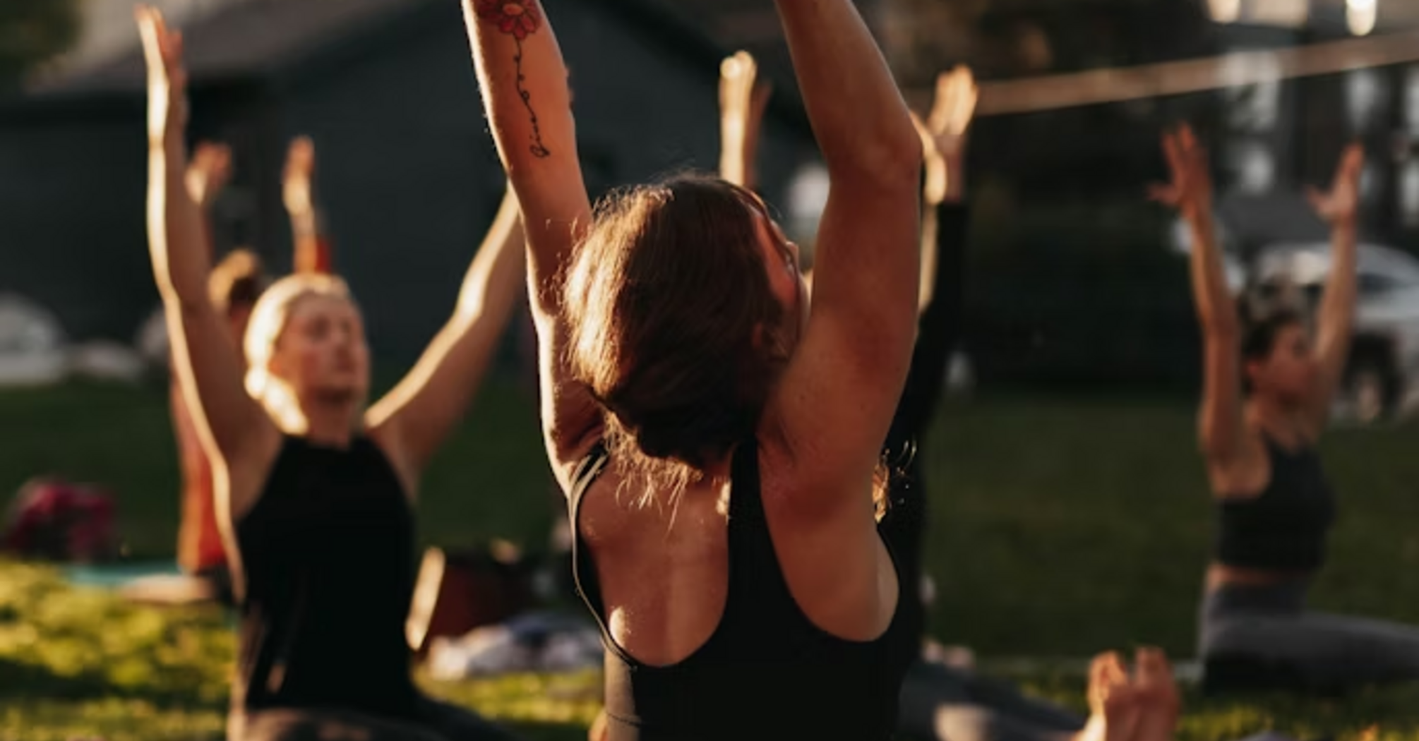 Group of people practicing outdoor yoga during a wellness retreat
