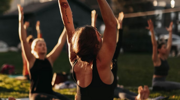 Group of people practicing outdoor yoga during a wellness retreat