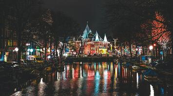 Night view of Amsterdam canal with historic building lit up