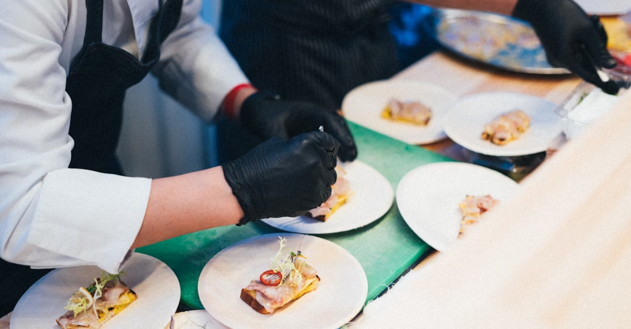 Chefs preparing plated regional dishes at an event