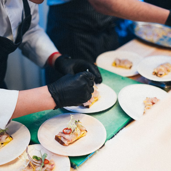 Chefs preparing plated regional dishes at an event