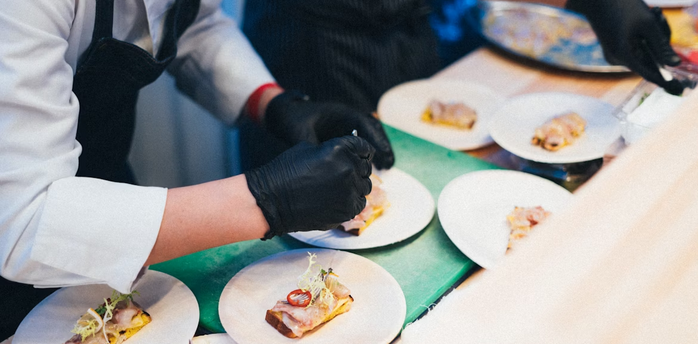 Chefs preparing plated regional dishes at an event