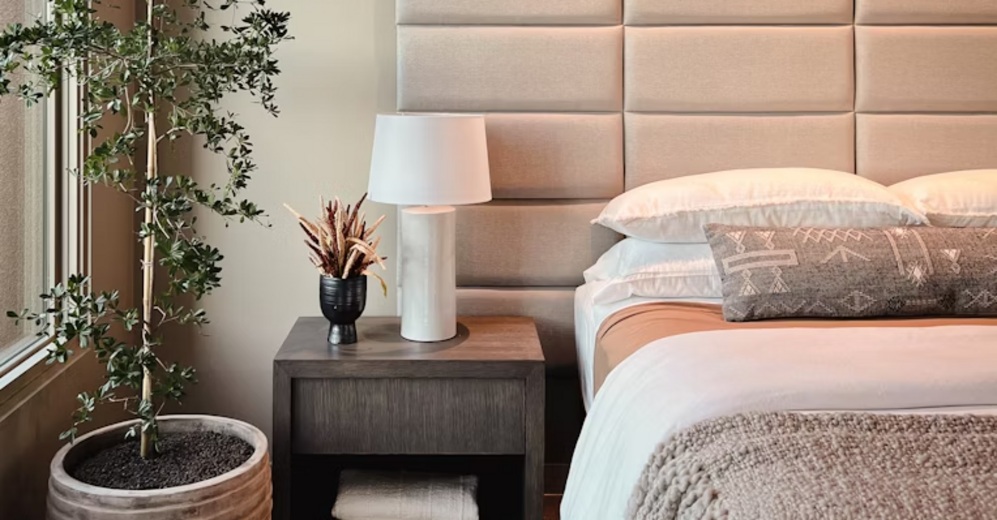 Modern hotel room with soft lighting, cozy bed, and minimal design