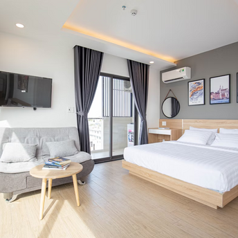 Modern hotel room with bed, sofa and balcony in daylight