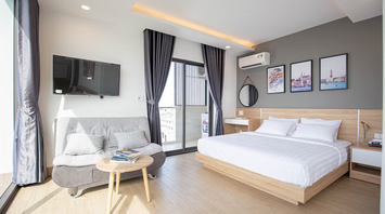 Modern hotel room with bed, sofa and balcony in daylight