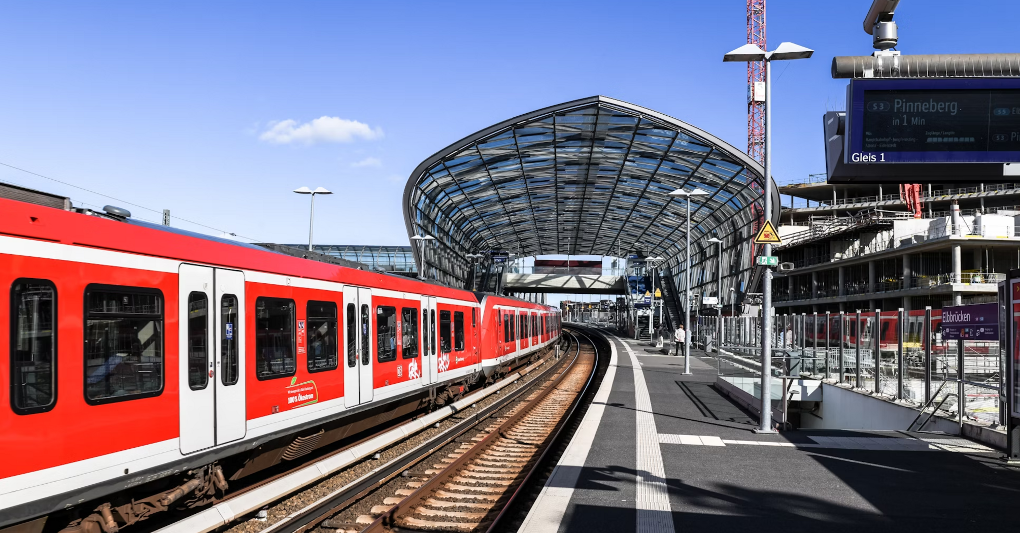 Red regional train at a modern glass-covered station platform in Germany