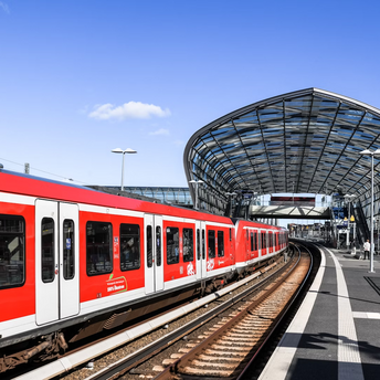Red regional train at a modern glass-covered station platform in Germany