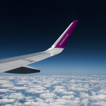 Wizz Air airplane wing above the clouds during flight