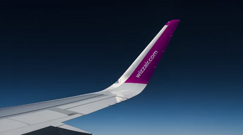 Wizz Air airplane wing above the clouds during flight