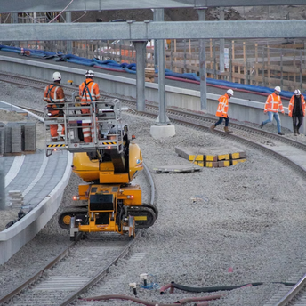 Workers carrying out railway track maintenance with heavy equipment