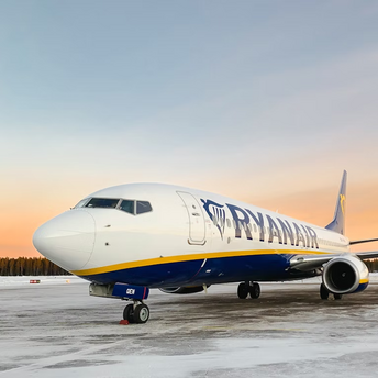 Ryanair aircraft on a snowy runway at sunset