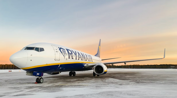 Ryanair aircraft on a snowy runway at sunset