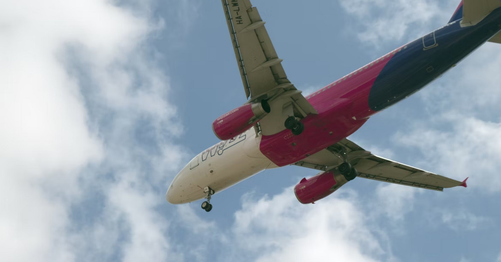 Wizz Air aircraft approaching for landing under blue sky
