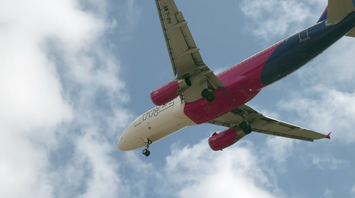 Wizz Air aircraft approaching for landing under blue sky