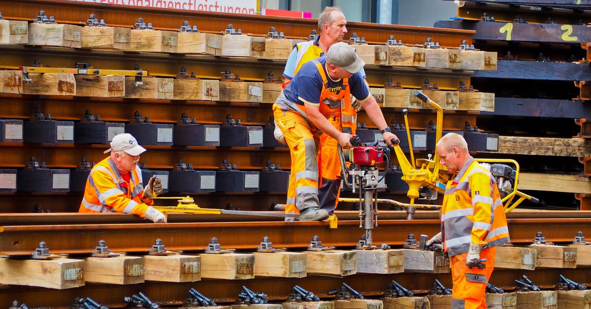 Railway workers in high-visibility clothing conducting track maintenance