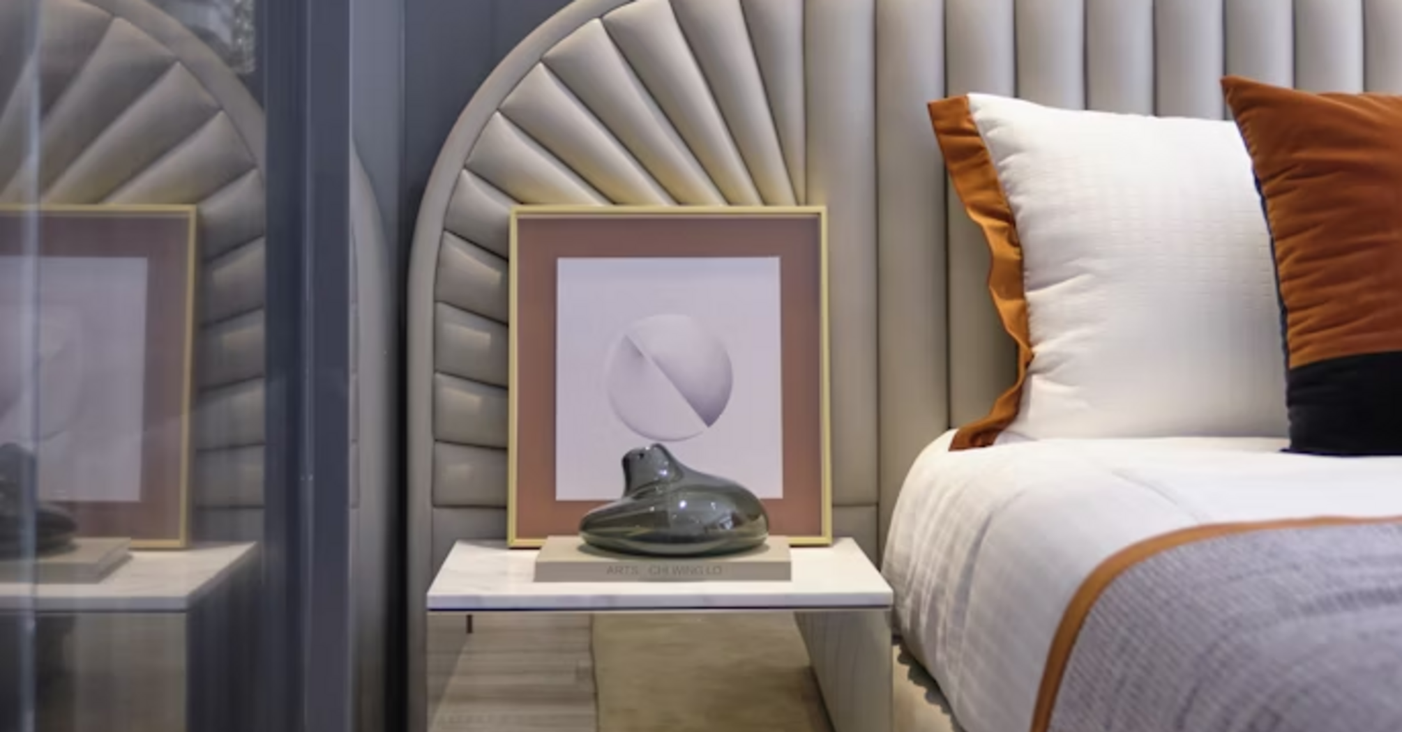 Modern hotel bedroom interior with neutral tones and accent pillows