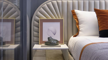 Modern hotel bedroom interior with neutral tones and accent pillows