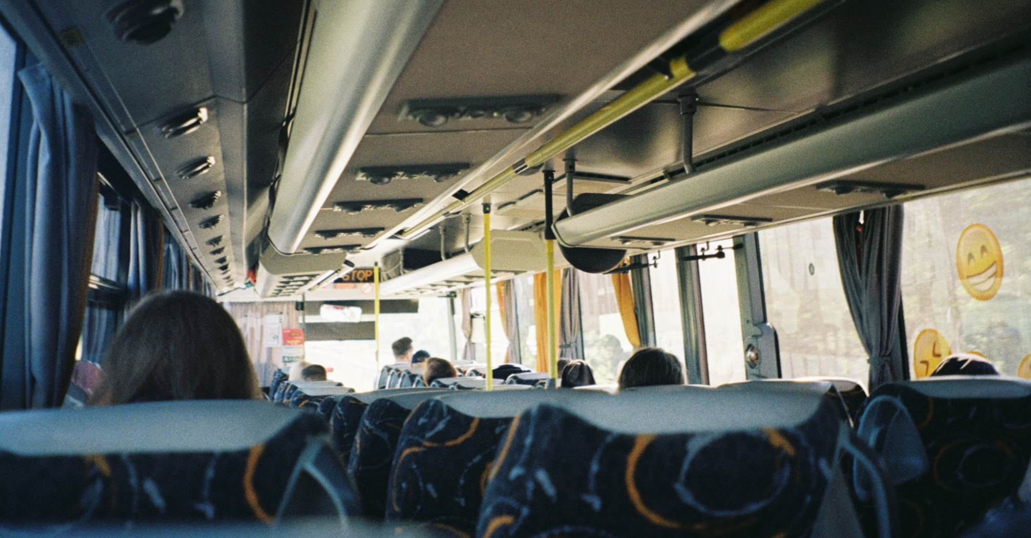 Interior of a local bus with passengers seated during daytime travel
