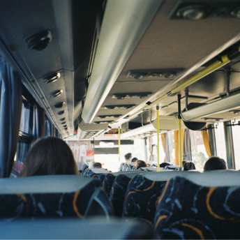 Interior of a local bus with passengers seated during daytime travel