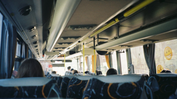 Interior of a local bus with passengers seated during daytime travel