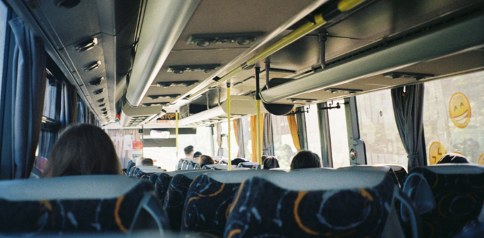 Interior of a local bus with passengers seated during daytime travel