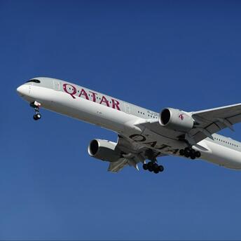 Qatar Airways aircraft in flight against clear sky
